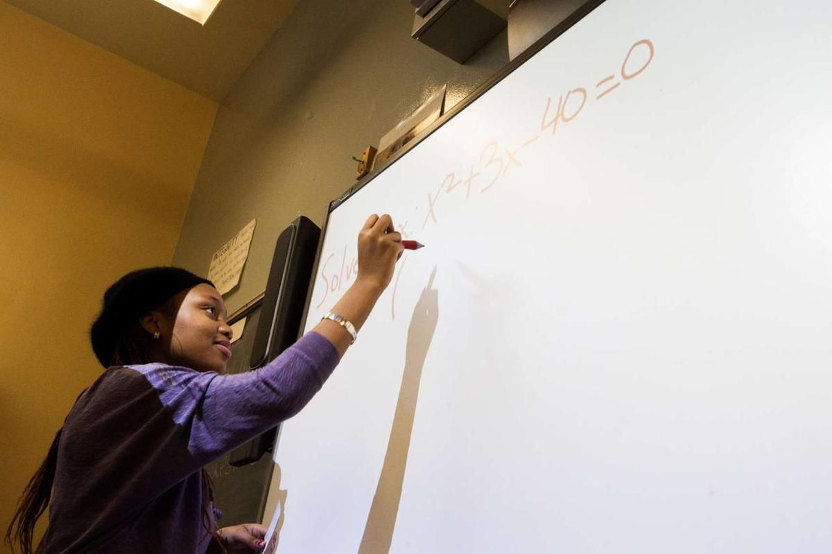 Belba Bangoura solves an equation during math class at Pathways in Technology Early College High School in Brooklyn, N.Y.