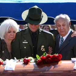 Cheryl Ivie, left, Joel Ivie and Doug Ivie comfort each other during the graveside services for their son and brother, U.S. Border Patrol agent Nicholas J. Ivie, in Spanish Fork, Thursday, Oct. 11, 2012.