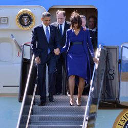 President Barack Obama  and first lady Michelle Obama depart Air Force One at Boston's Logan International Airport in Boston, Thursday, April 18, 2013, before attending an interfaith service for the victims of the bombings at the finish line of the Boston Marathon. Also seen is  Rep. Michael Capuano, D-Mass. is at center. 