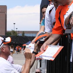 Head Coach John Fox signs autographs for fans after practice Wednesday.