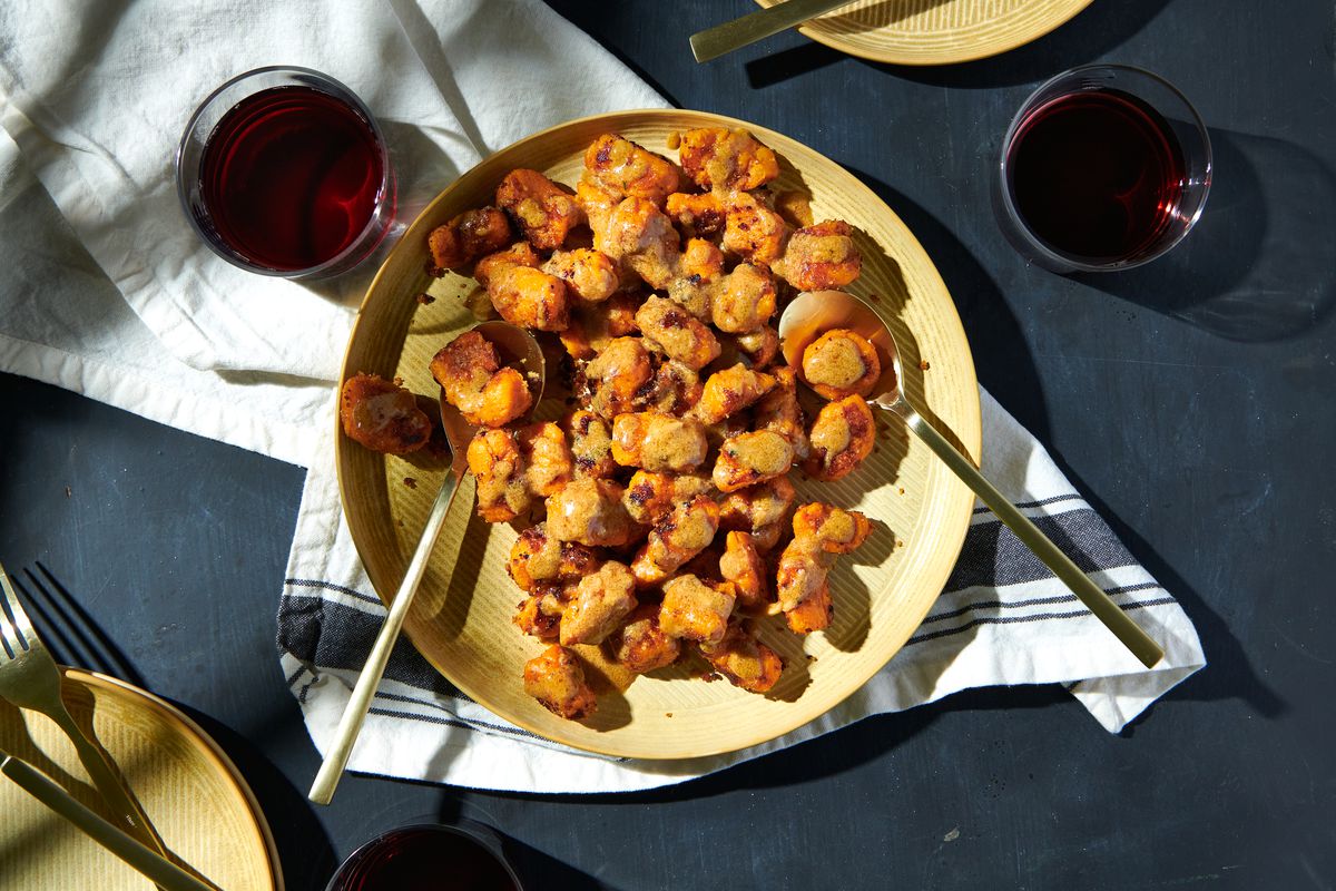 A big plate of yam gnocchi, accompanied by two glasses of red wine.