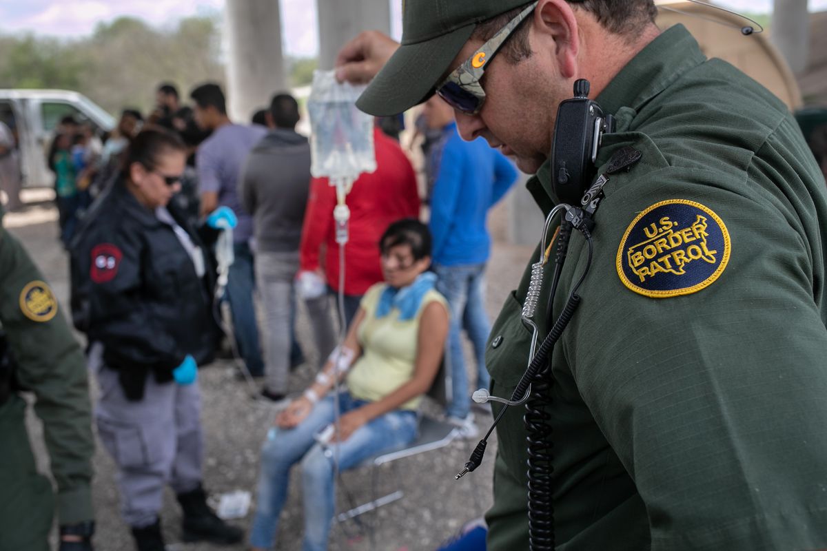 A US Border Patrol agent assists an immigrant in McAllen, Texas.