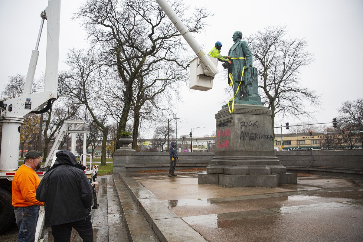 A worker takes a strap off of the statue of former president William McKinley that was vandalized with graffiti at McKinley Park near the 3700 block of South Archer Avenue in McKinley Park, Wednesday, Nov. 25, 2020.