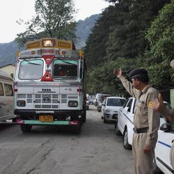 Indian policemen keep a check on vehicles after an American woman was gang-raped Tuesday in the northern Indian resort town of Manali, India, Tuesday, June 4, 2013. The 30-year-old woman was picked up early Tuesday morning by men in a truck as she was hitchhiking back to her guest house after visiting a friend, police officer Sher Singh said. (AP Photo)
