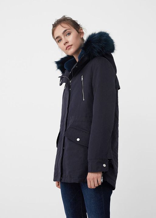 A woman in a navy coat with faux fur trim