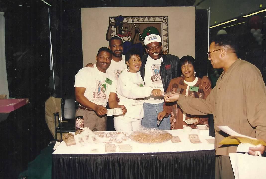 Customers with Norwood Clark Jr. at a Uncle Darrow’s Cajun Candy Company stand selling pralines.