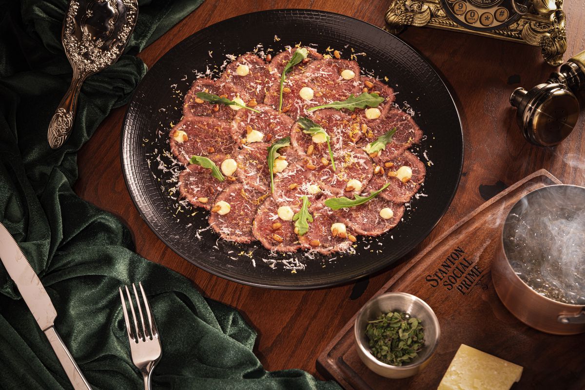 Prime beef carpaccio with greens and pine nuts.