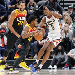 Utah Jazz guard Donovan Mitchell (45) dribbles the ball past New Orleans Pelicans forward Herbert Jones (5) as Utah Jazz center Rudy Gobert (27) watches during an NBA game at Vivint Arena in Salt Lake City on Saturday, Nov. 27, 2021.