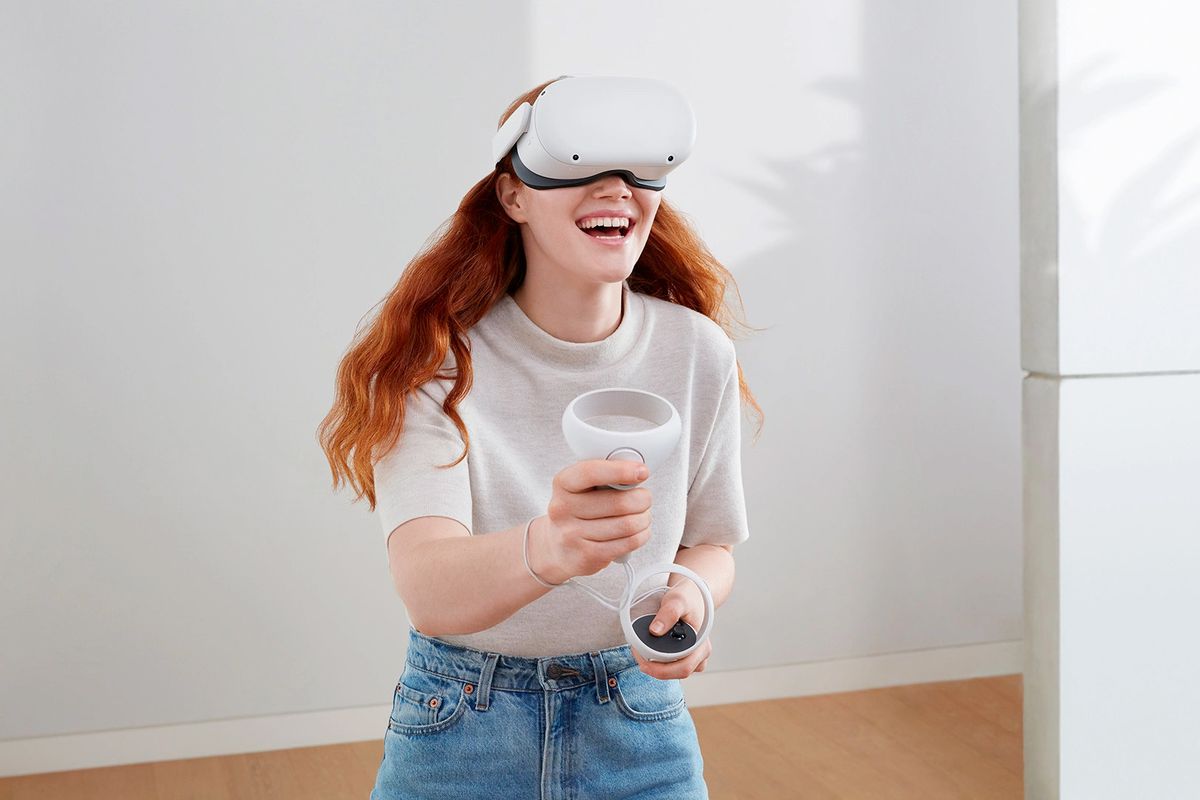 A woman wearing a Meta Quest 2 headset smiles as she experiences VR
