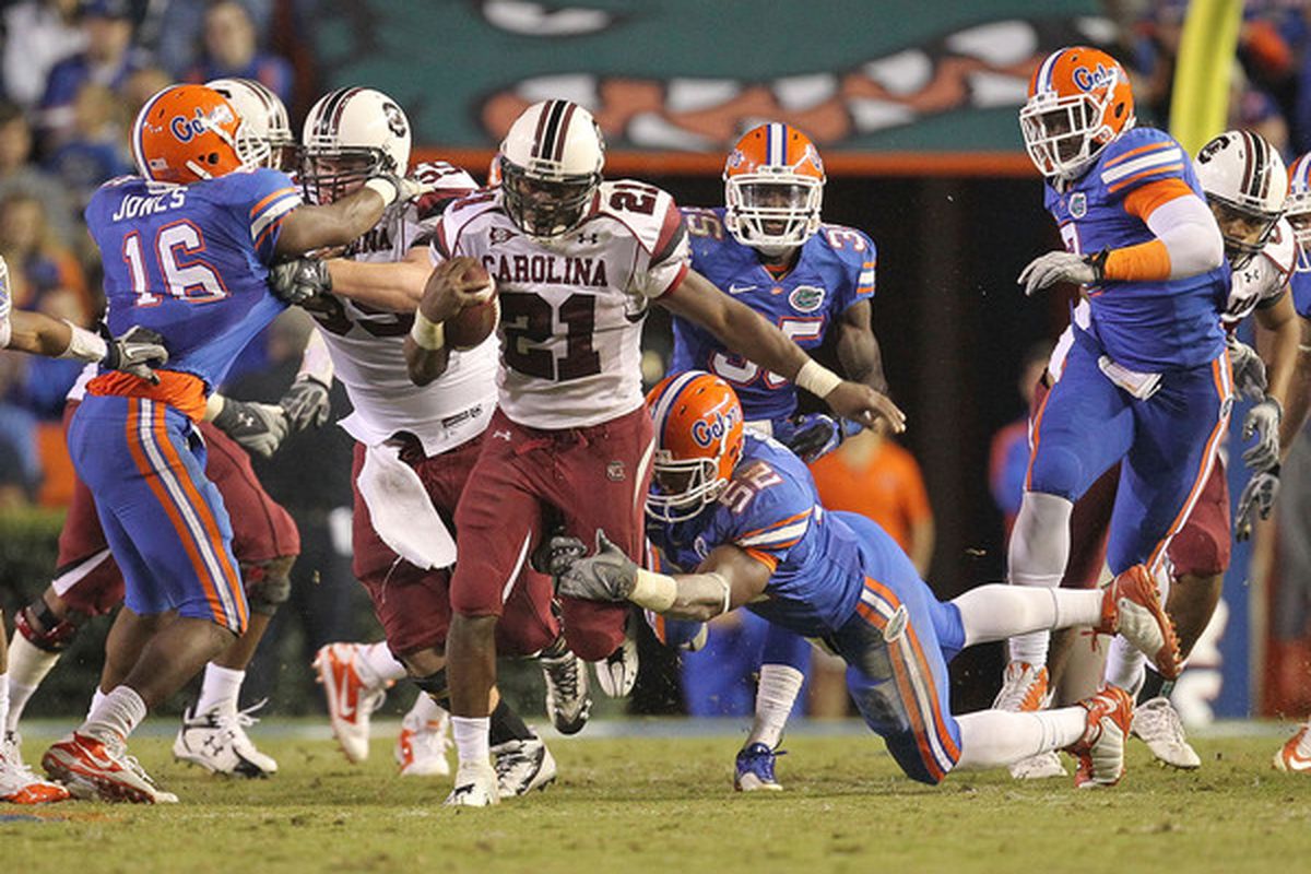 GAINESVILLE FL - NOVEMBER 13:  Marcus Lattimore #21 of the South Carolina Gamecocks rushes against Jonathan Bostic #52 of the Florida Gators at Ben Hill Griffin Stadium on November 13 2010 in Gainesville Florida.  (Photo by Mike Ehrmann/Getty Images)