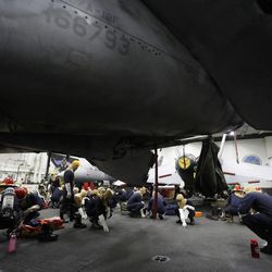 U.S. Navy sailors conduct a drill exercise inside the hangar bay of the U.S.S. Dwight D. Eisenhower aircraft carrier on Tuesday, Nov. 22, 2016. The carrier is currently deployed in the Persian Gulf, supporting Operation Inherent Resolve, the military operation against Islamic State extremists in Syria and Iraq. 