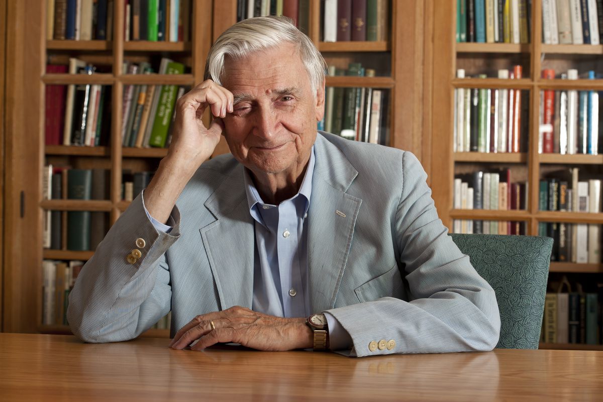 Naturalist E.O. Wilson sitting at a table in a library.