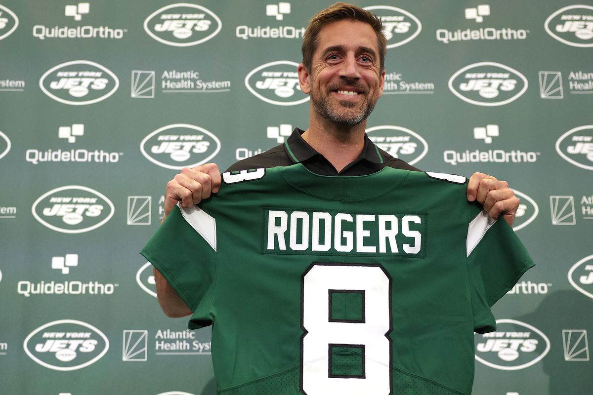 New York Jets quarterback Aaron Rodgers poses with a jersey during an introductory press conference at Atlantic Health Jets Training Center on April 26, 2023 in Florham Park, New Jersey.