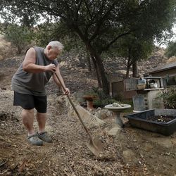 Bill Susel, 77, removes debris from a gully in back of his home on Spring Trail in Kagel Canyon, in preparation for expected heavy rains later tonight, Monday, Jan. 8, 2018. (Mel Melcon/Los Angeles Times via AP)