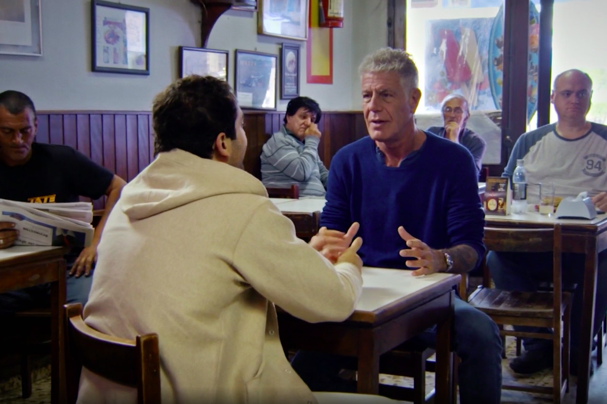 Anthony Bourdain sitting in a restaurant in a clip from the Uruguay episode of parts unknown