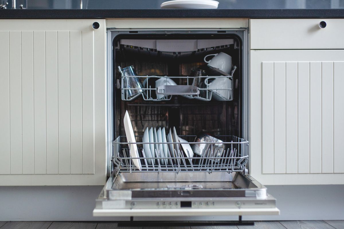 An open dishwasher with dishes inside
