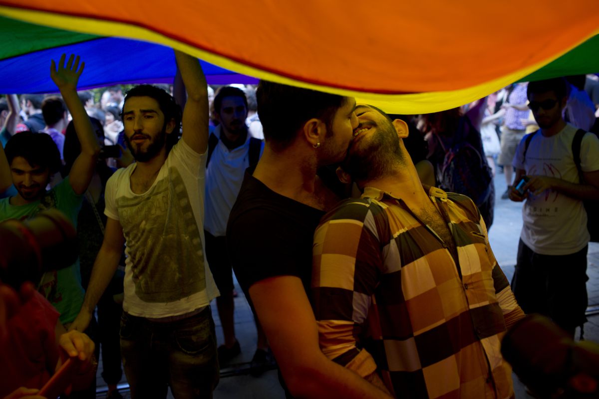 A picture of two men kissing under a pride flag at Istanbul’s pride parade