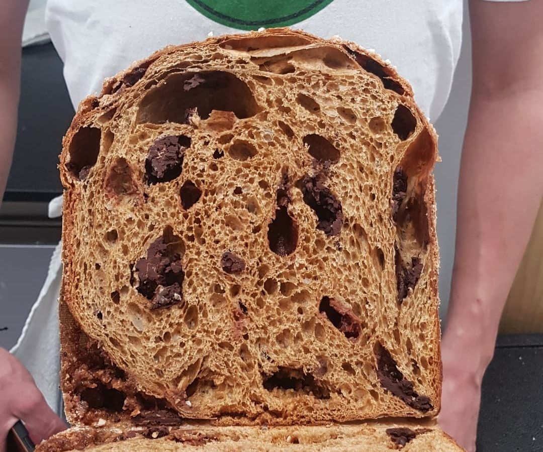 person holding panettone cut through the center