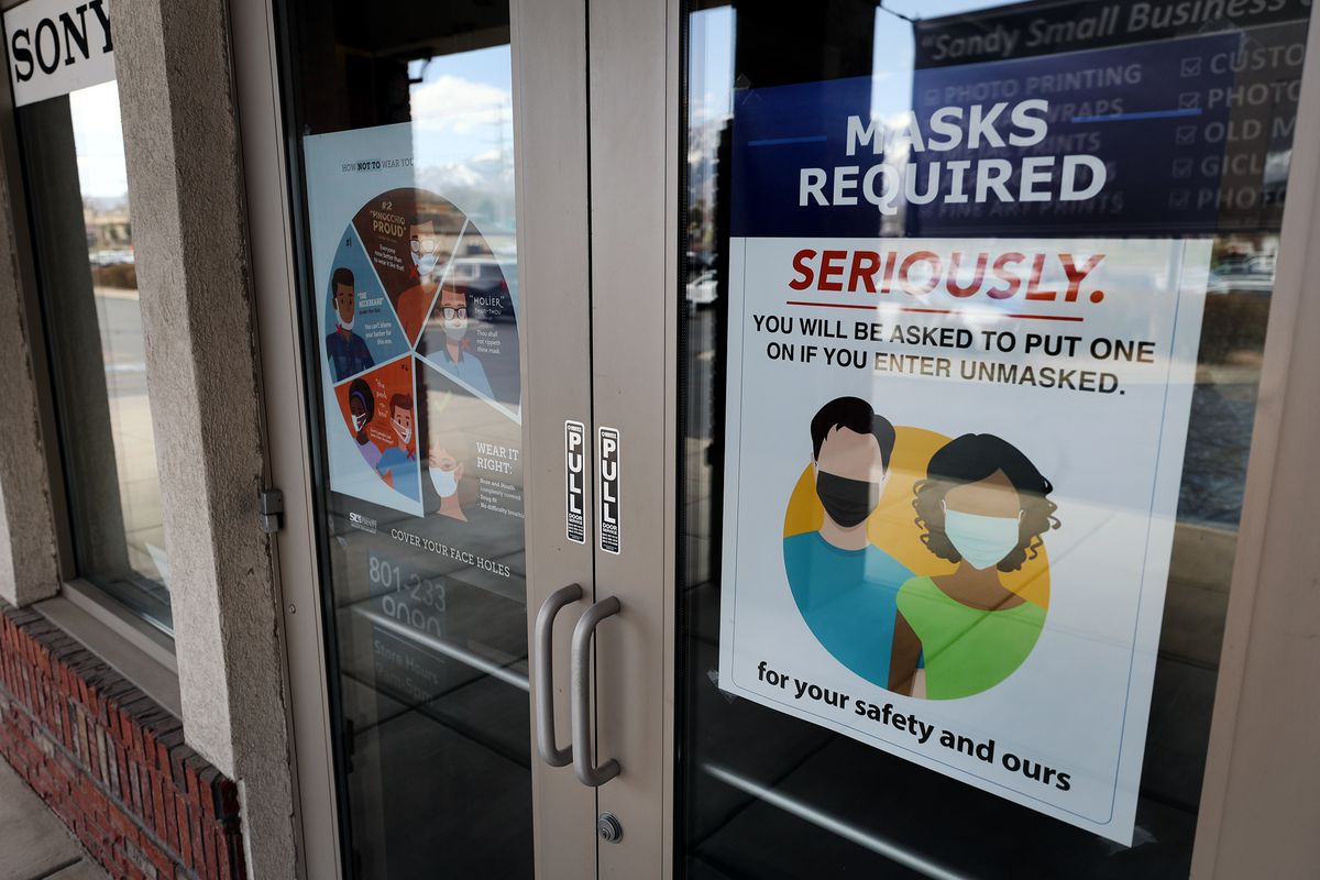 “Masks required” signage is pictured on the front doors of Pixels Foto &amp; Frame in Sandy on Monday, April 5, 2021.