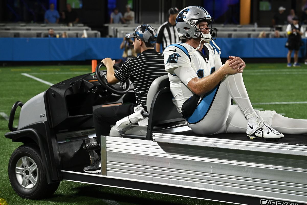 Sam Darnold #14 of the Carolina Panthers gets driven off the field after a third quarter injury against the Buffalo Bills during a preseason game at Bank of America Stadium on August 26, 2022 in Charlotte, North Carolina.