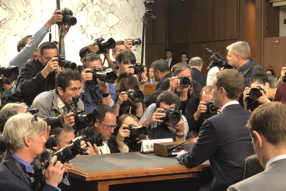 Facebook CEO Mark Zuckerberg, seated at the table where he will testify to Congress, surrounded by photographers