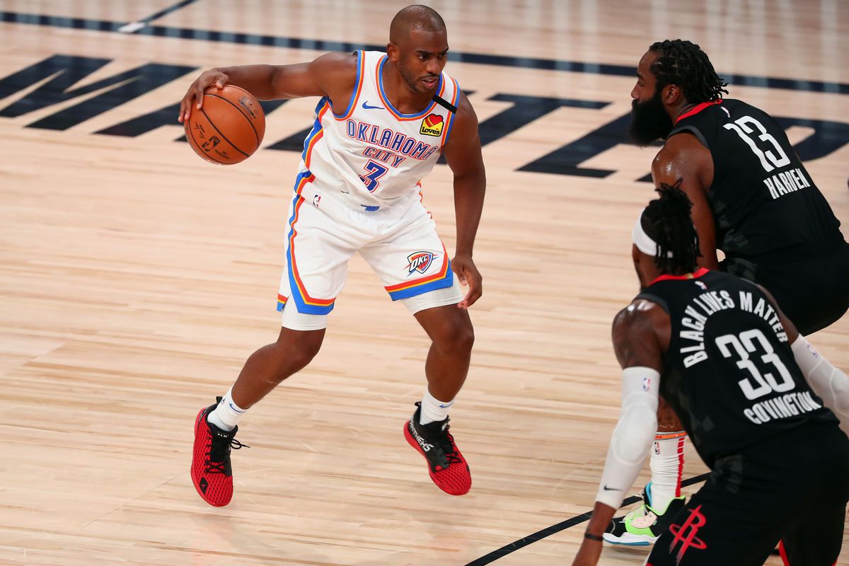 Oklahoma City Thunder guard Chris Paul drives against Houston Rockets forward Robert Covington and guard James Harden (13) during the first half of game seven of the first round of the 2020 NBA Playoffs at ESPN Wide World of Sports Complex.