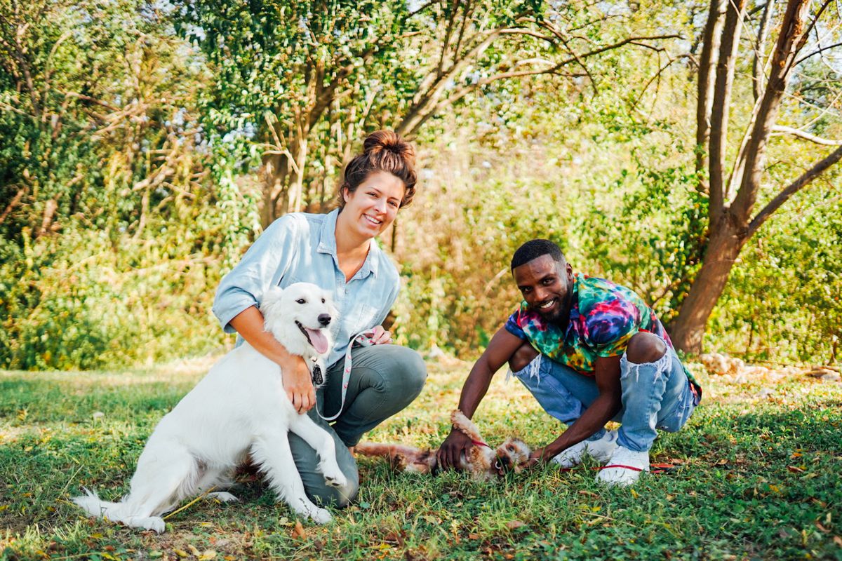 Kati Luedecke and Lamar Bowman in a park with a dog.
