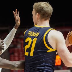 Utah center Lahat Thioune, left, attempts to defend the pass of California forward Lars Thiemann (21) during an NCAA game at the Huntsman Center in Salt Lake City on Sunday, Dec. 5, 2021.