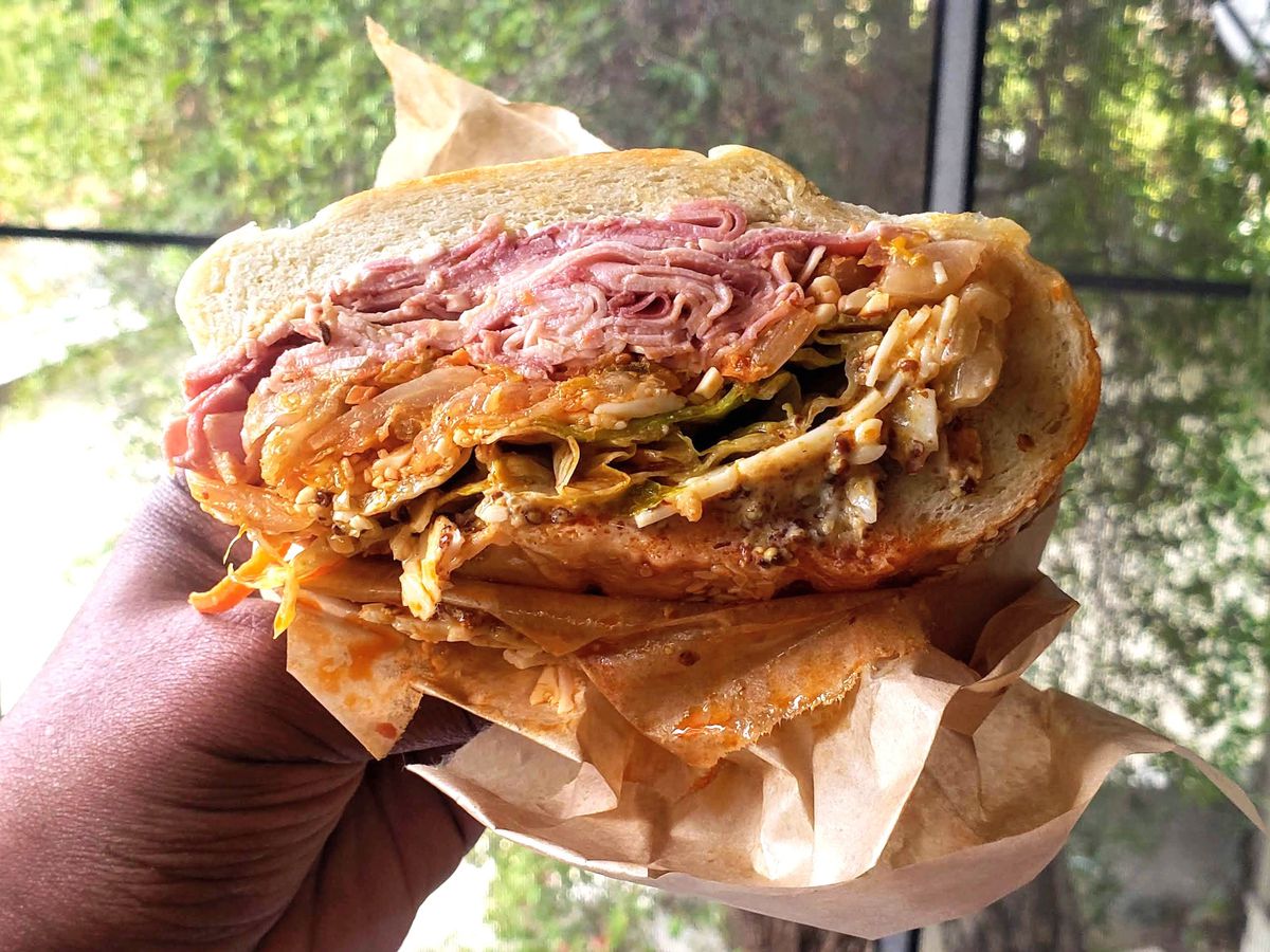A layered sandwich with pork, kimchi, melted cheese, salted plum mustard, and aioli from Jeff’s Table.