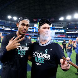 OCTOBER 08: Julio Rodriguez #44 and Scott Servais #9 of the Seattle Mariners celebrate on the field after defeating the Toronto Blue Jays in game two to win the American League Wild Card Series at Rogers Centre on October 08, 2022 in Toronto, Ontario.