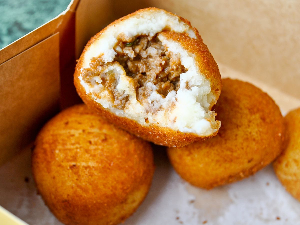 Potato balls open to reveal meat inside from a Cuban bakery.