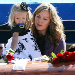 Christy Ivie, wife of U.S. Border Patrol agent Nicholas J. Ivie, helps her 3-year-old daughter, Raigan, place a flower on the casket of her husband at the end of a graveside ceremony in Spanish Fork, Thursday, Oct. 11, 2012.