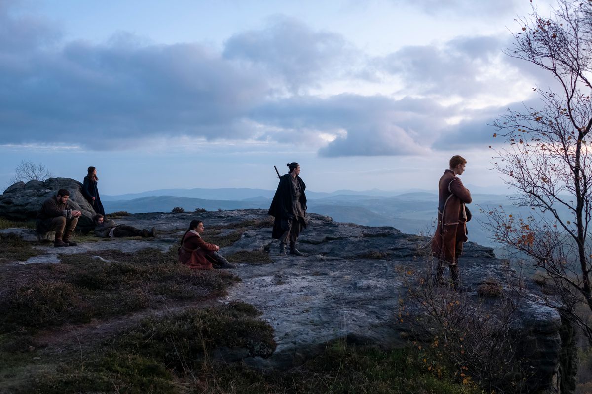 The cast of Wheel of Time stand in a picturesque cliff in a season 1 still of the Amazon show.