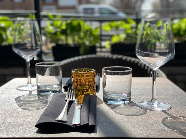 Wine and water glasses on an outdoor table with a napkin and silverware.