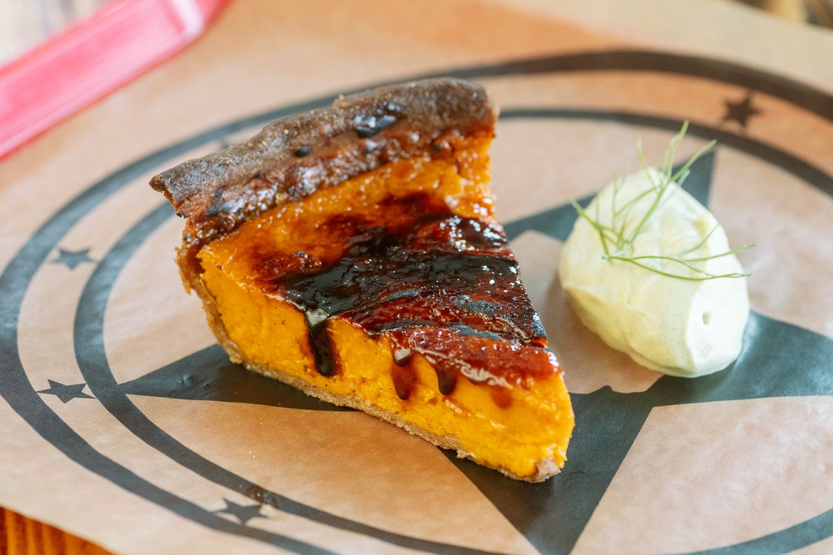 A piece of sweet potato pie is caramelized and served with whipped cream.