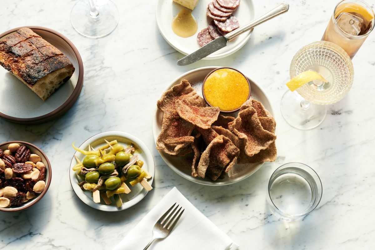An overhead photograph of a gildas, bread, sliced meat, and other snacks at a restaurant, Cecily.
