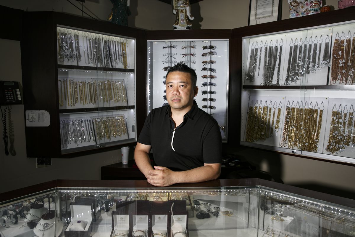 Gary Yee, manager of Golden Sun Jewelry, stands in front of some of the Cartier sunglasses he sells.