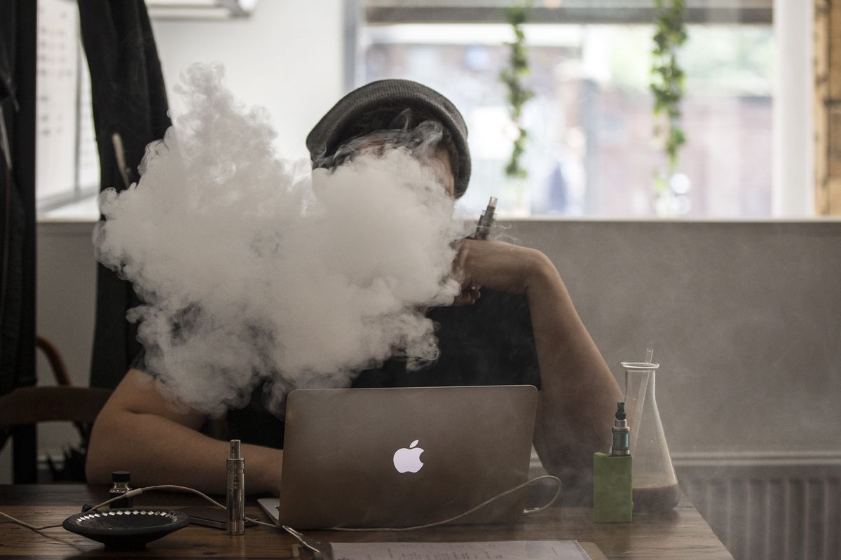  A man smokes an e-cigarette in the Vape Lab coffee bar, on August 27, 2014, in London, England.