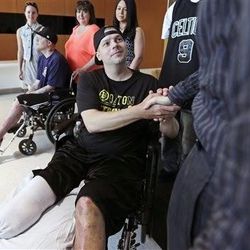 Boston Marathon bombing survivor J.P. Norden, of Stoneham, Mass., shakes hands with his physician Dr. David Crandell while getting released from Spaulding Rehabilitation Hospital in Boston, Friday. At far left is J.P.'s brother Paul Norden, who was released earlier in the month.