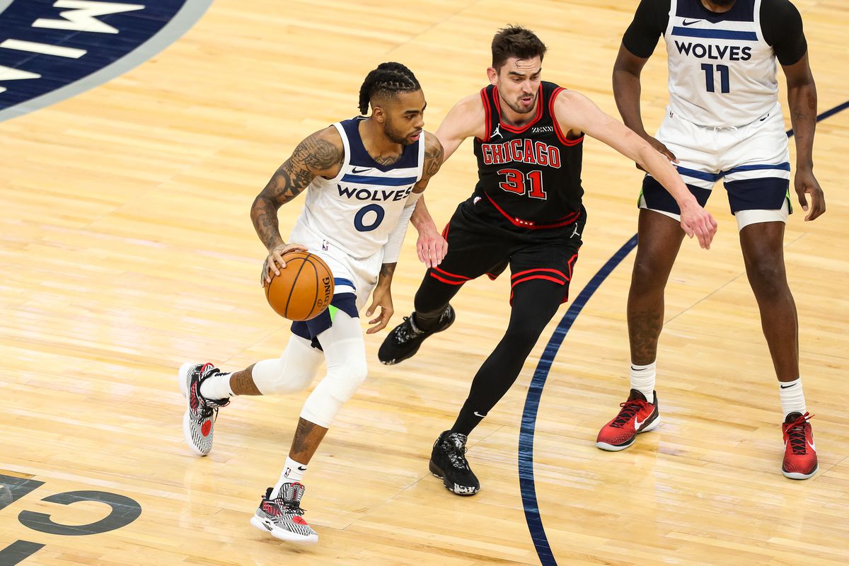 D’Angelo Russell of the Minnesota Timberwolves dribbles the ball while Tomas Satoransky of the Chicago Bulls defends in the first quarter of the game at Target Center on April 11, 2021 in Minneapolis, Minnesota.
