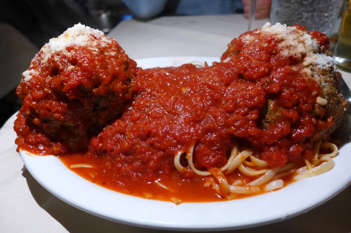 A pair of extraordinary size meatballs smothered in tomato sauce.
