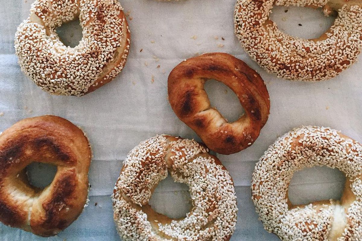 A top-down look at some loose Montreal-style bagels fresh from an oven, sitting on linen.