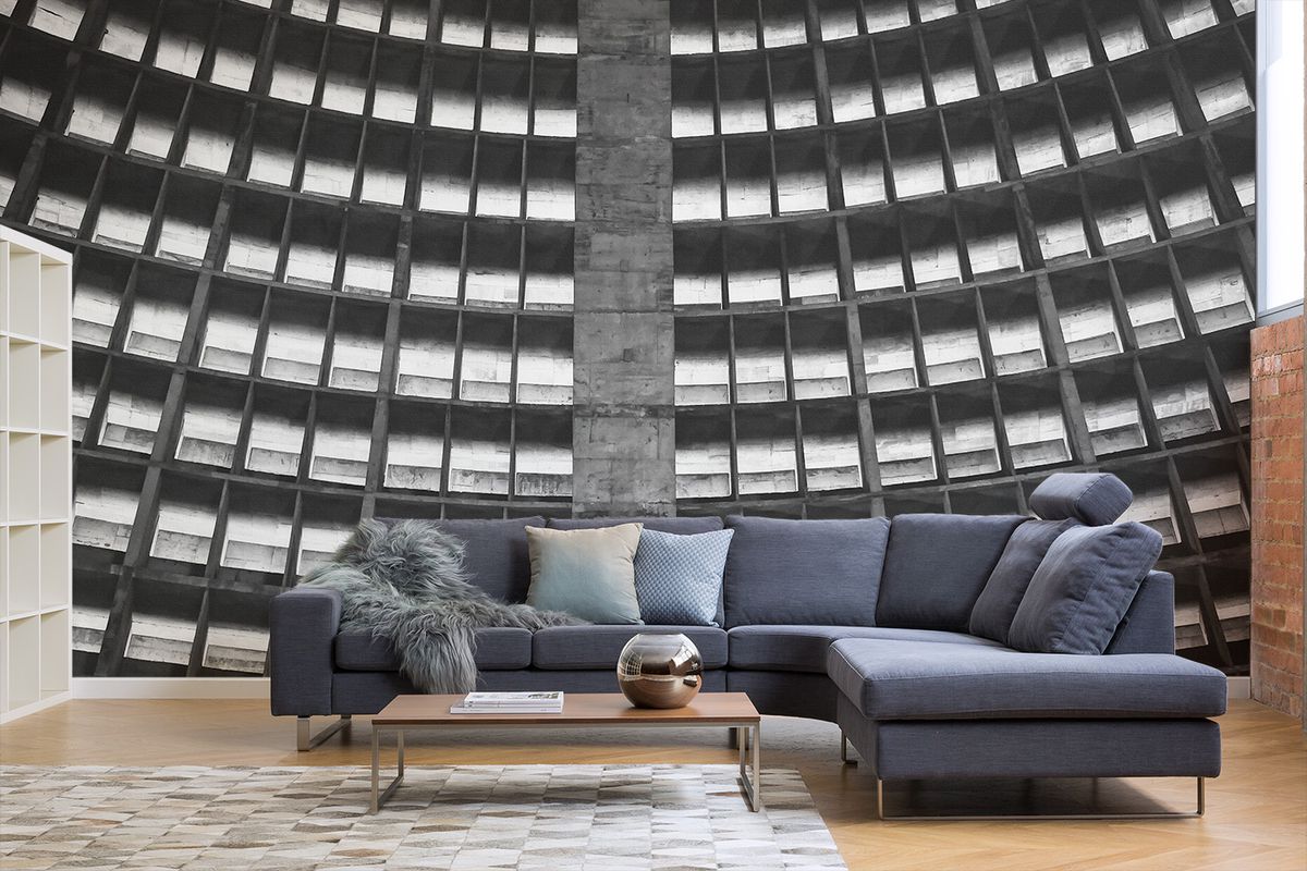 Living room scene with modern furniture and a backdrop of the inside of a concrete cathedral. 