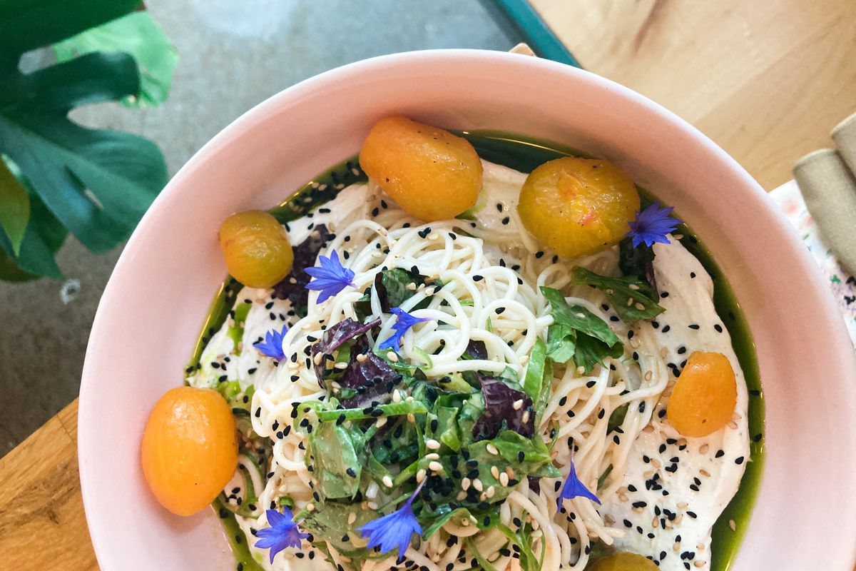 A bowl of noodles with cherry tomatoes, ricotta, and edible flowers at Hissyfit.