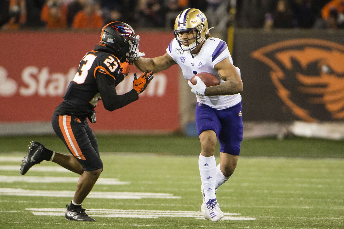 Washington Huskies tight end Hunter Bryant stiff arms Oregon State Beavers defensive back Isaiah Dunn after catching a pass during the second half at Reser Stadium.