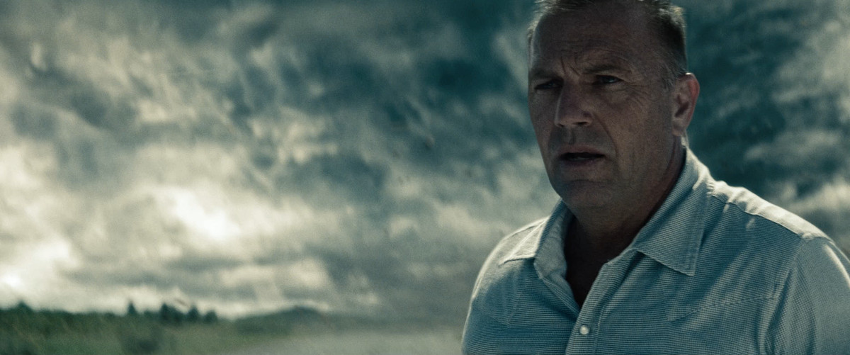 Kevin Costner in Man of Steel, with stormy clouds behind him and concern on his face.