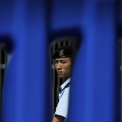 A policeman stands guard behind barriers outside the Central Government Office building in Hong Kong, Friday, July 5, 2019. Student unions from two Hong Kong universities said Friday that they have turned down invitations from city leader Carrie Lam for talks about the recent unrest over her proposal to allow the extradition of suspects to mainland China. (AP Photo/Andy Wong)