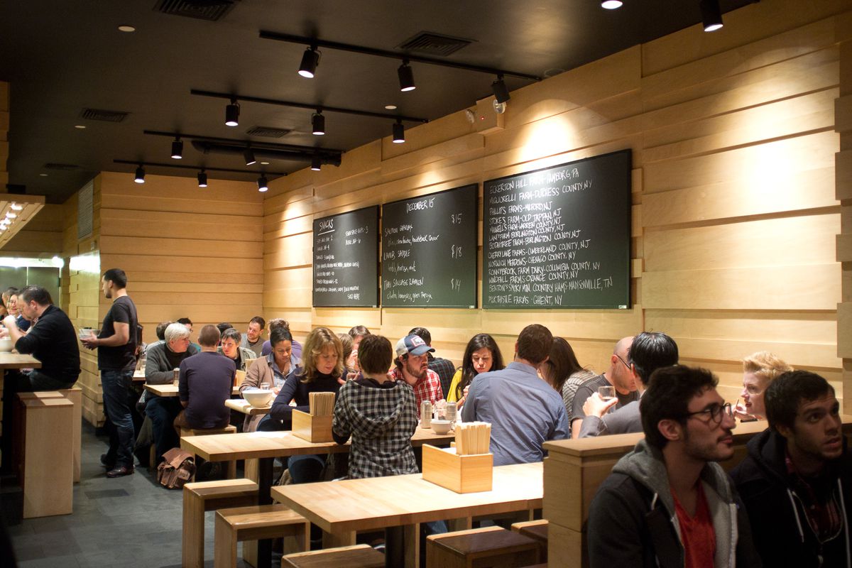 People dining inside Momofuku Noodle Bar’s wood-filled interior