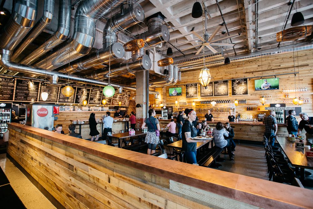 Customers fill communal tables at the wood-paneled Jolly Pumpkin in Detroit. 