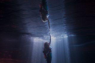 Изстрел от малката русалка на Ариел, докосваща повърхността на водата